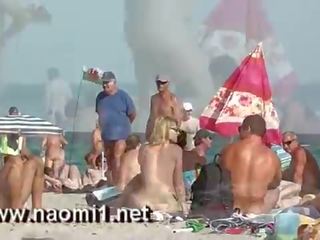 Naomi1 paja un joven joven en un público playa